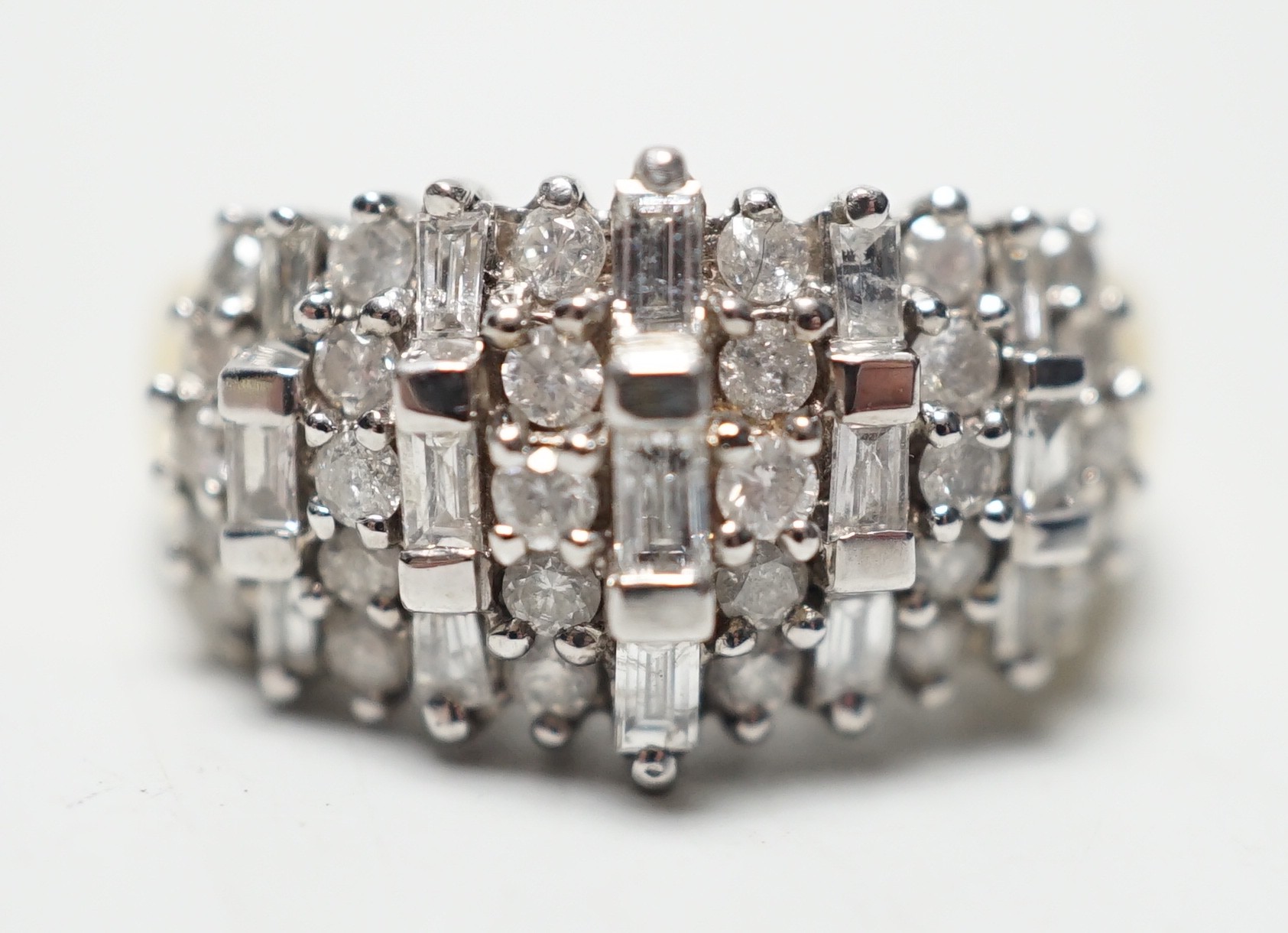 A modern yellow metal, round and baguette cut diamond set half hoop cluster ring, size L/M, gross weight 5.6 grams.